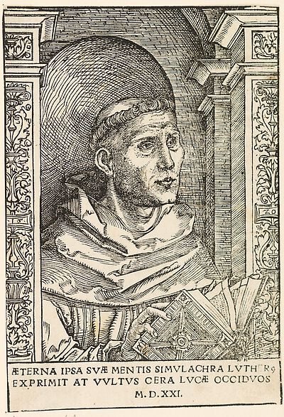 Martin Luther als Augustinermönch im Ordenshabit, Halbfigur nach rechts gewandt, mit Buch, vor einer halbrunden Nische, unter gestaffelten Rundbogen, mit Kämpfergesimsen und Ornamentpilastern