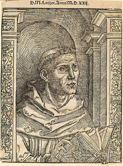 Martin Luther als Augustinermönch im Ordenshabit, Halbfigur nach rechts, mit Buch, vor einer halbrunden Nische, unter gestaffelten Bögen mit Kämpfergesimsen und Ornamentpilastern