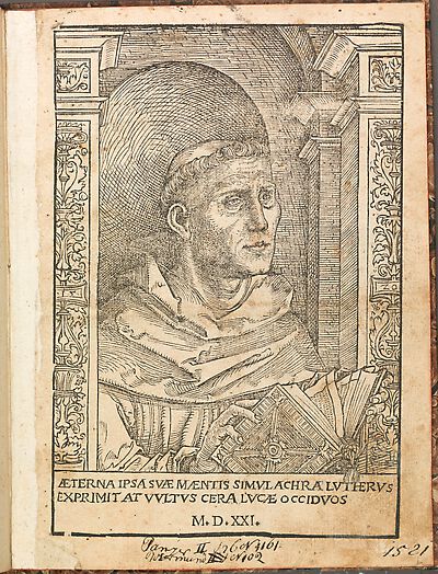 Martin Luther als Augustinermönch im Ordenshabit, Halbfigur nach rechts gewandt, mit Buch, vor einer halbrunden Nische, unter gestaffelten Rundbogen, mit Kämpfergesimsen und Ornamentpilastern