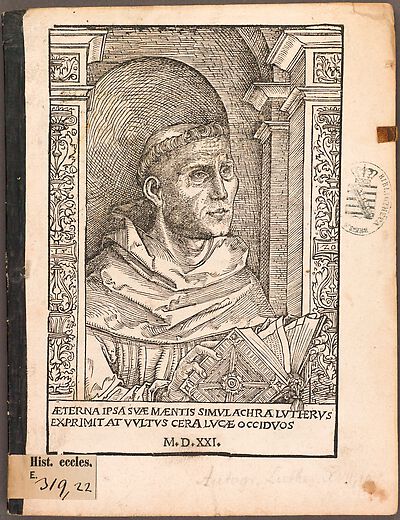 Martin Luther als Augustinermönch im Ordenshabit, Halbfigur nach rechts gewandt, mit Buch, vor einer halbrunden Nische, unter gestaffelten Rundbogen, mit Kämpfergesimsen und Ornamentpilastern