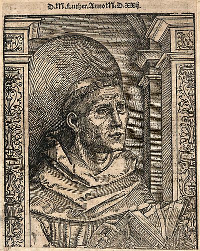 Martin Luther als Augustinermönch im Ordenshabit, Halbfigur nach rechts gewandt, mit Buch, vor einer halbrunden Nische, unter gestaffelten Rundbogen, mit Kämpfergesimsen und Ornamentpilastern