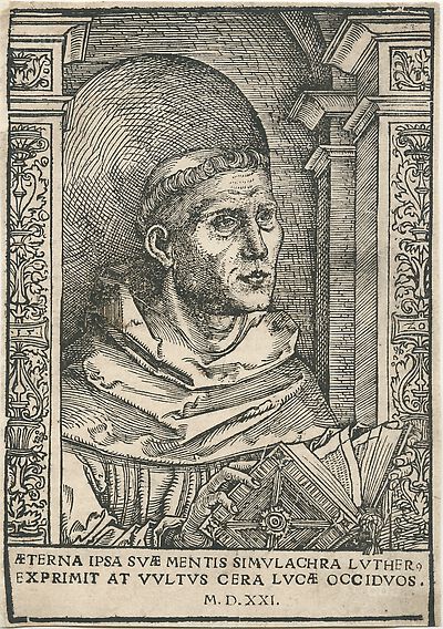Martin Luther als Augustinermönch im Ordenshabit, Halbfigur nach rechts, mit Buch, vor einer halbrunden Nische, unter gestaffelten Bögen mit Kämpfergesimsen und Ornamentpilastern, mit Inschrift